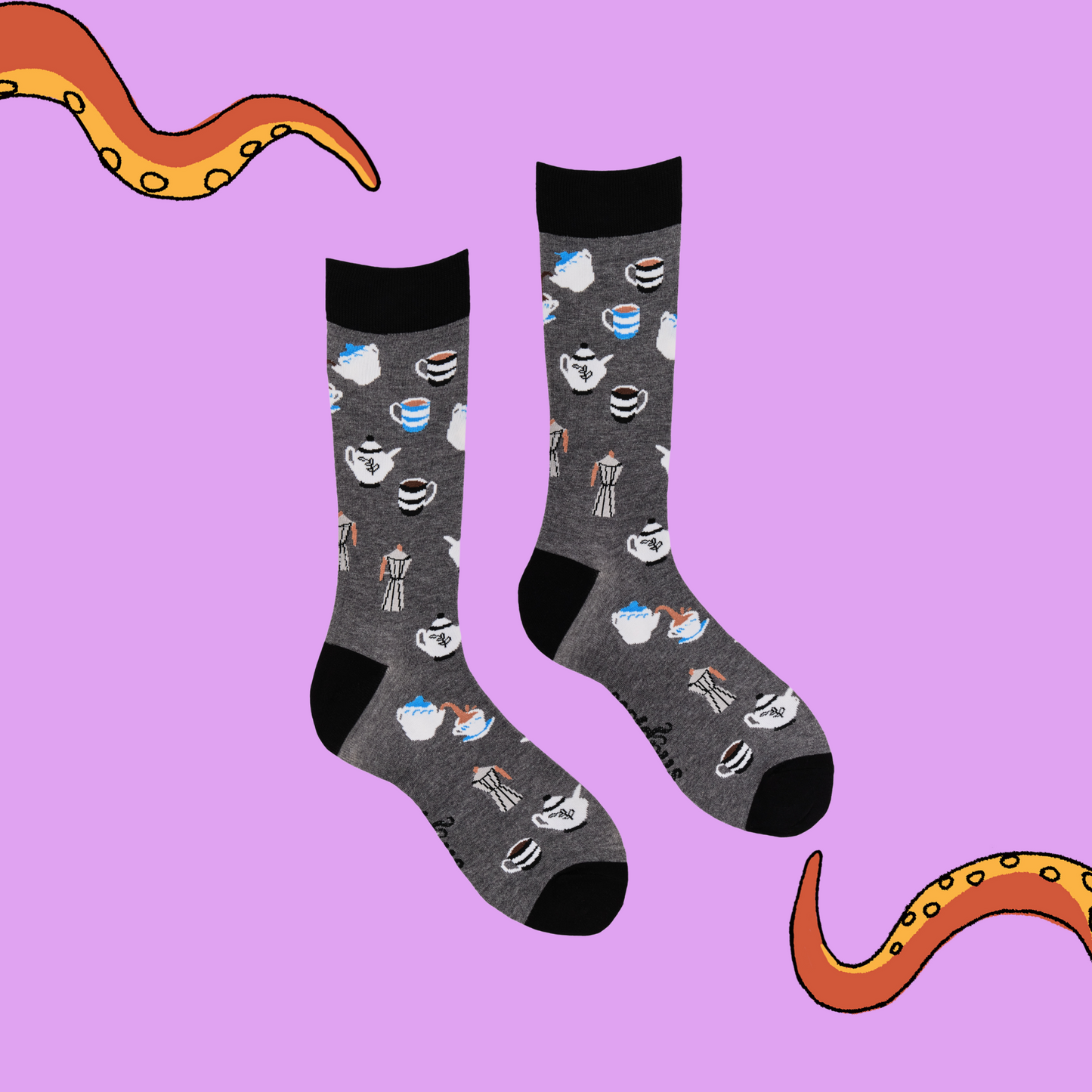 
                  
                    A pair of socks depicting tea cups and tea pots. Grey legs, black cuff, heel and toe.
                  
                