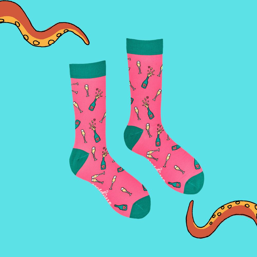 
                  
                    A pair of socks depicting champagne bottles and glasses. Pink legs, turquoise cuff, heel and toe.
                  
                