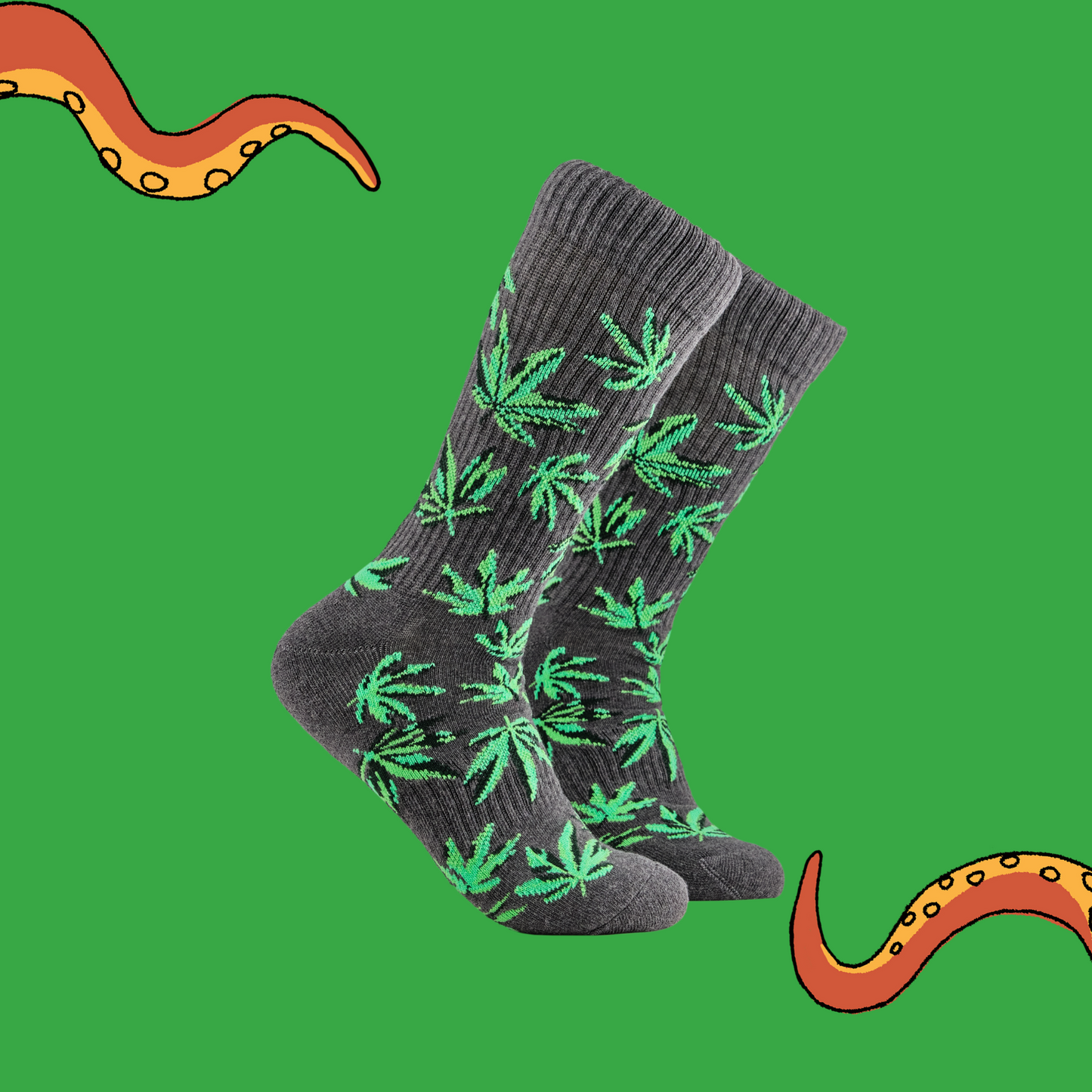A pair of socks depicting cannabis leaves. Grey athletic legs, grey cuff, heel and toe.