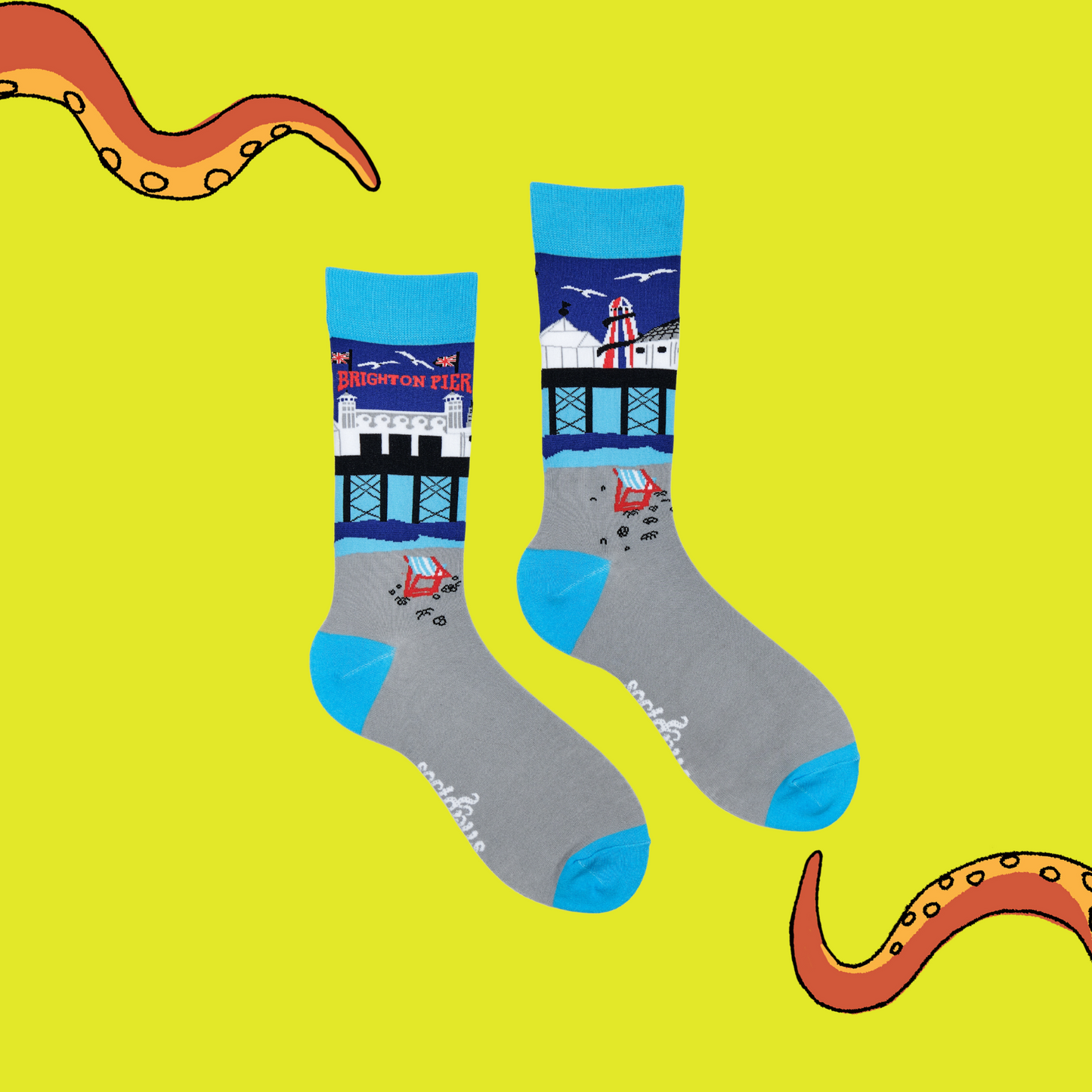 
                  
                     A pair of socks depicting Brighton Pier. Grey legs, light blue cuff, heel and toe.
                  
                