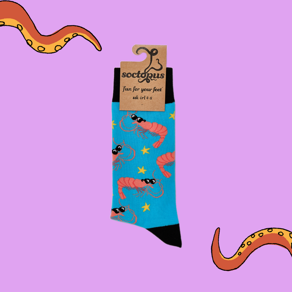 
                  
                    A pair of socks depicting cool prawns in sunglasses. Bright blue legs, black cuff, heel and toe. In Soctopus Packaging.
                  
                