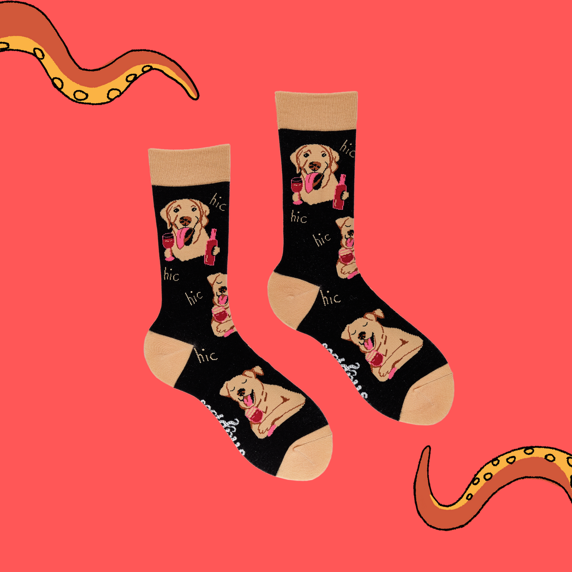 A pair of socks depicting labs drinking wine. Black legs, light brown cuff, heel and toe.