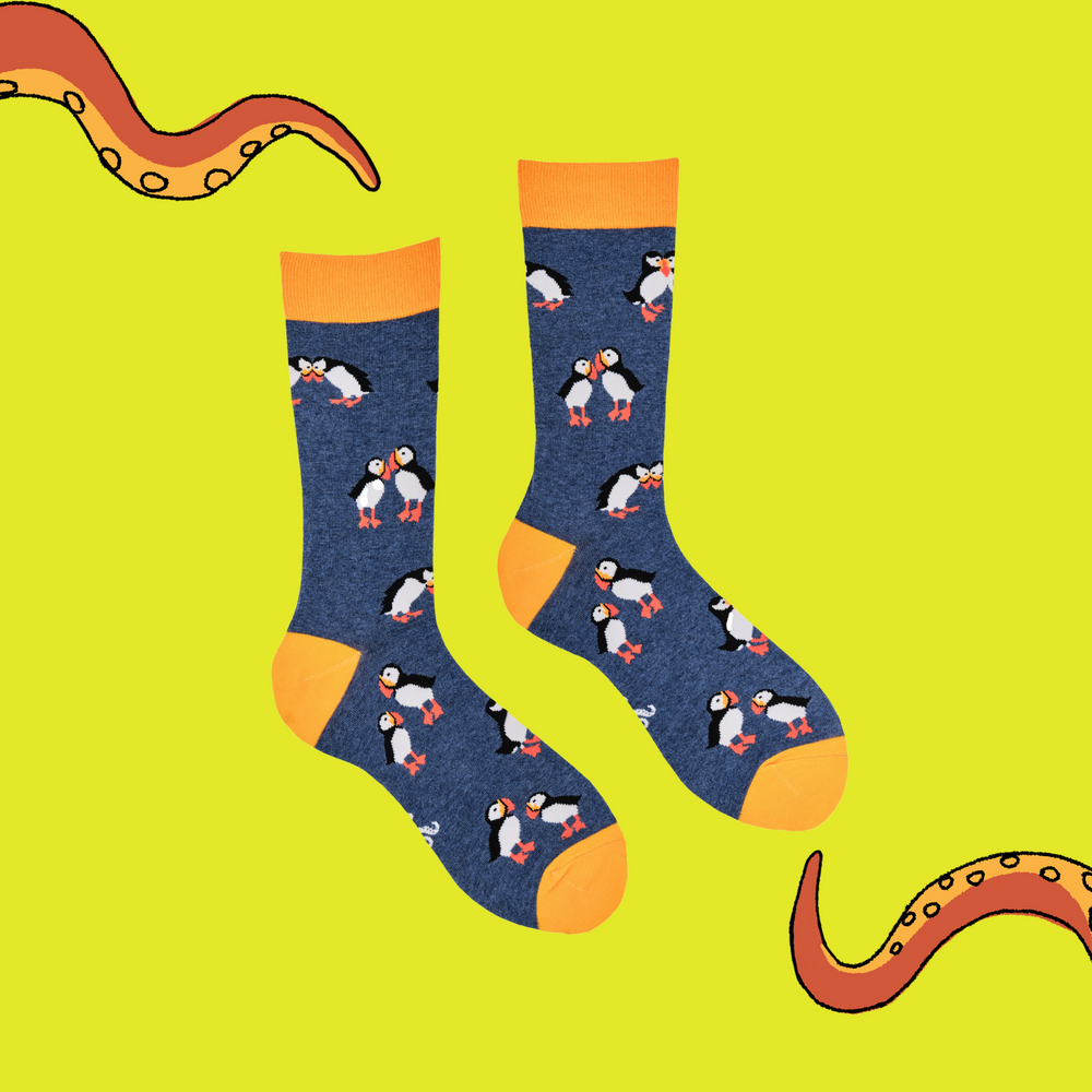 
                  
                    A pair of socks depicting tea cups and tea pots. Blue legs, yellow cuff, heel and toe.
                  
                