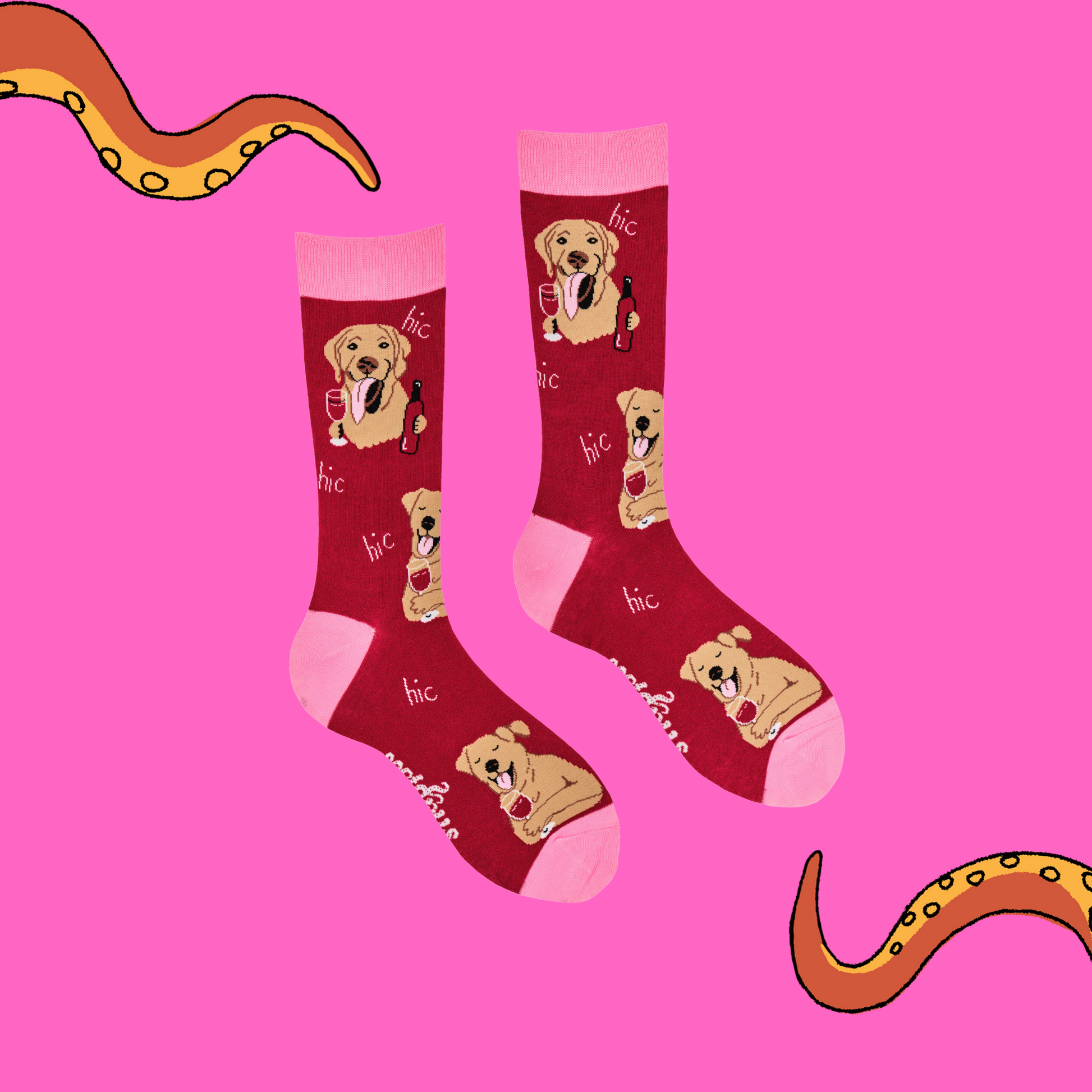 A pair of socks depicting labs drinking wine. Red legs, light pink cuff, heel and toe.