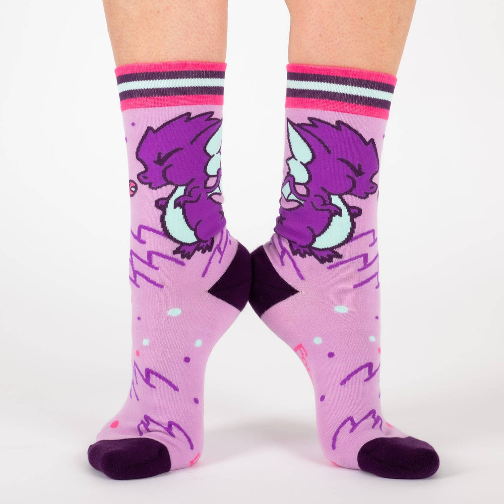 
                      
                        A model wearing a pair of socks featuring a cute dragon motif. Pink legs, purple heel, toe and cuff. 
                      
                    