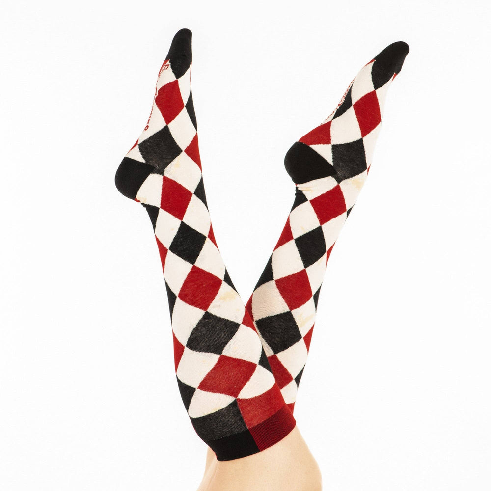 
                      
                        A model wearing a pair of knee high socks with a harlequin pattern. Black, white and red.
                      
                    