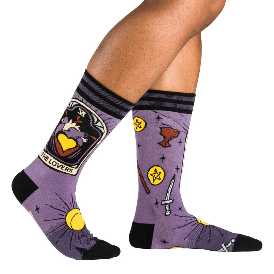 
                      
                        A model wearing a pair of socks depicting the lovers tarot card and tarot symbols. Purple legs, black heel toe and cuff. 
                      
                    