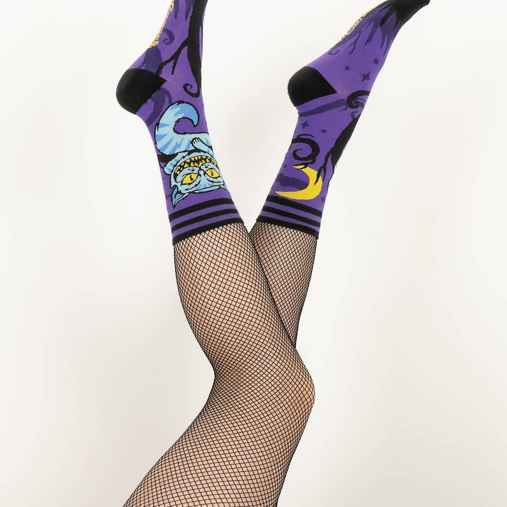 
                      
                        A model wearing a pair of socks featuring the cheshire cat. Purple legs, black heel, cuff and toe. 
                      
                    