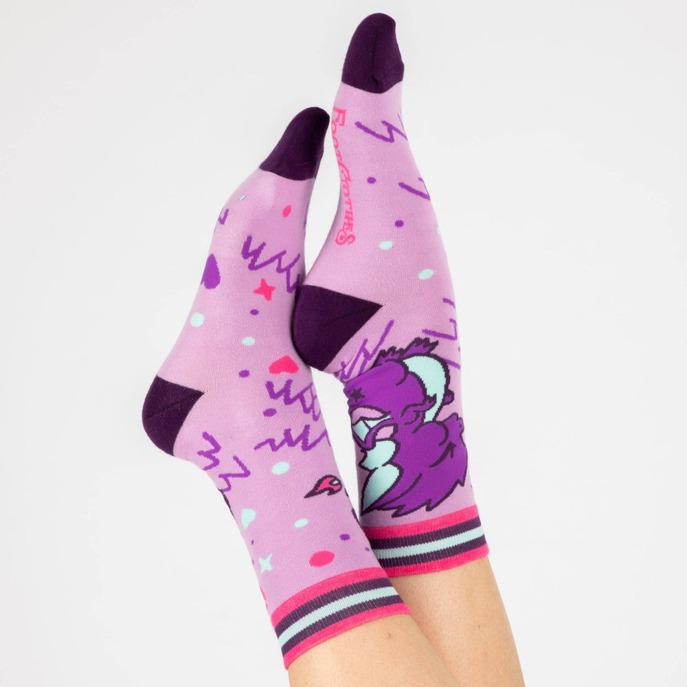 
                      
                        A model wearing a pair of socks featuring a cute dragon motif. Pink legs, purple heel, toe and cuff. 
                      
                    