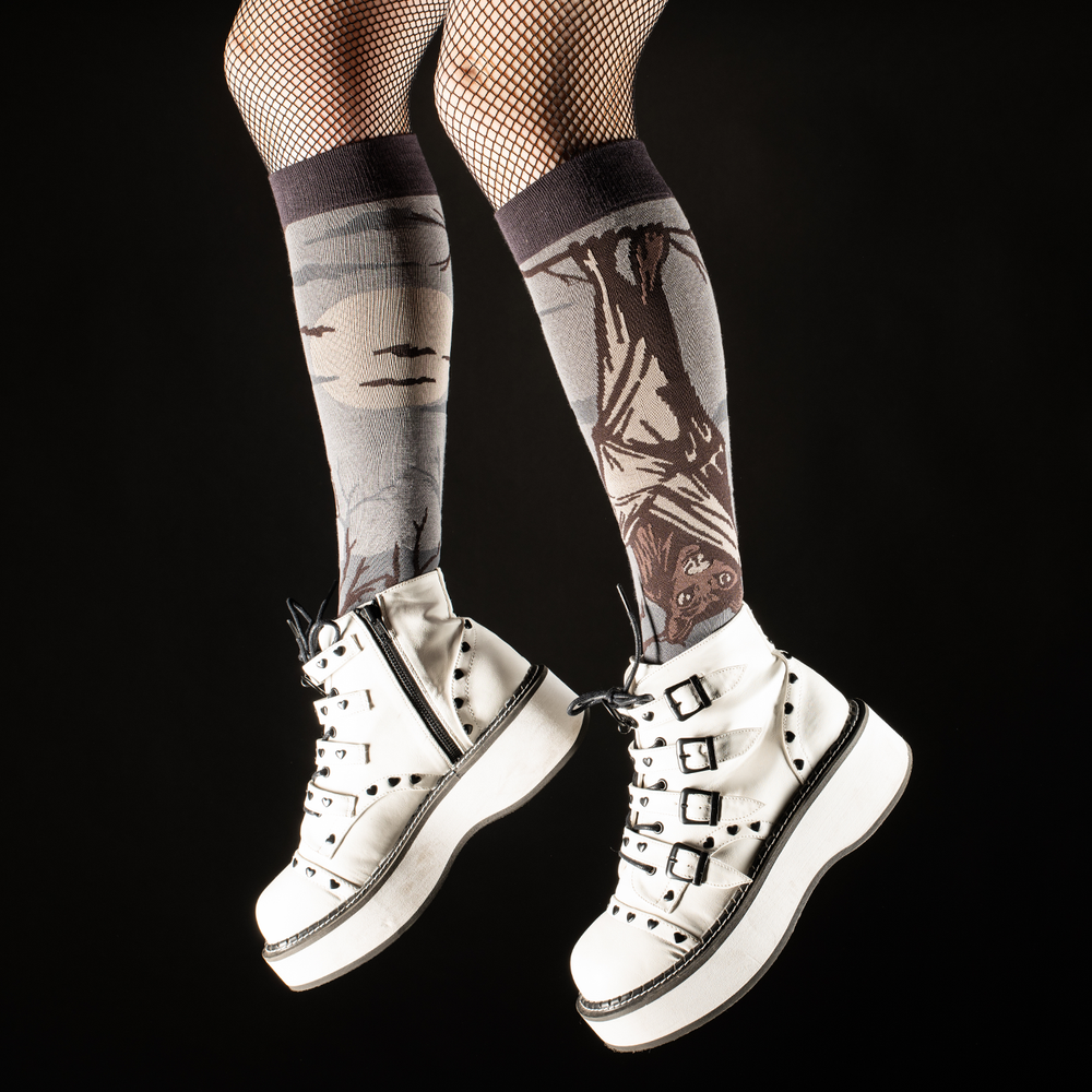 
                      
                        Model wearing a pair of socks depicting a spooky vampire bat. Knee high for comfort. Grey toe, heel and cuff. 
                      
                    