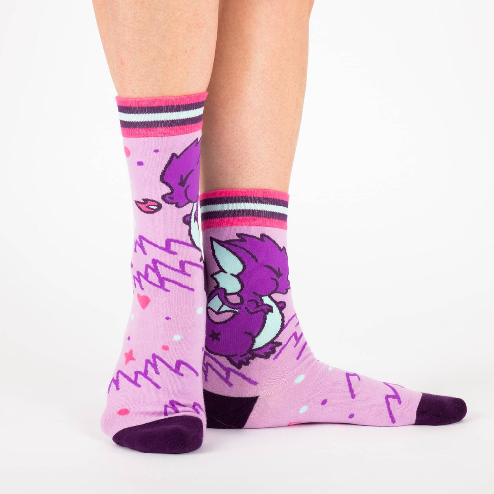 
                      
                        A model wearing a pair of socks featuring a cute dragon motif. Pink legs, purple heel, toe and cuff. 
                      
                    