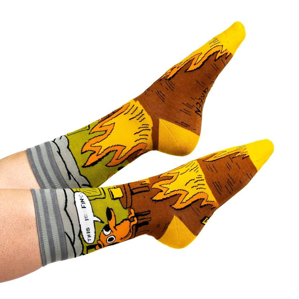 
                      
                        A model wearing a pair of socks featuring a design by KC Green. Brown flaming legs, yellow heel, toe and cuff. 
                      
                    