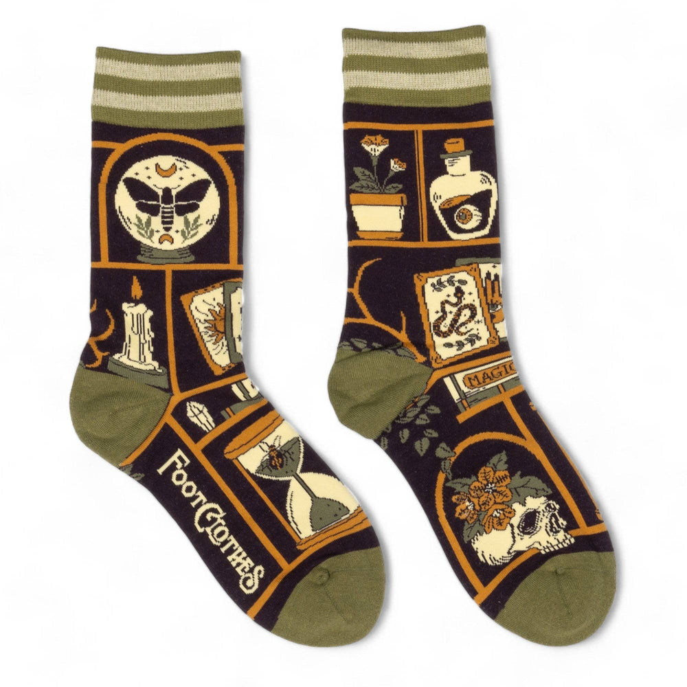 
                      
                        A model wearing a pair of socks depicting a collection of odd objects. Brown legs, green, heel, toe and cuff. 
                      
                    