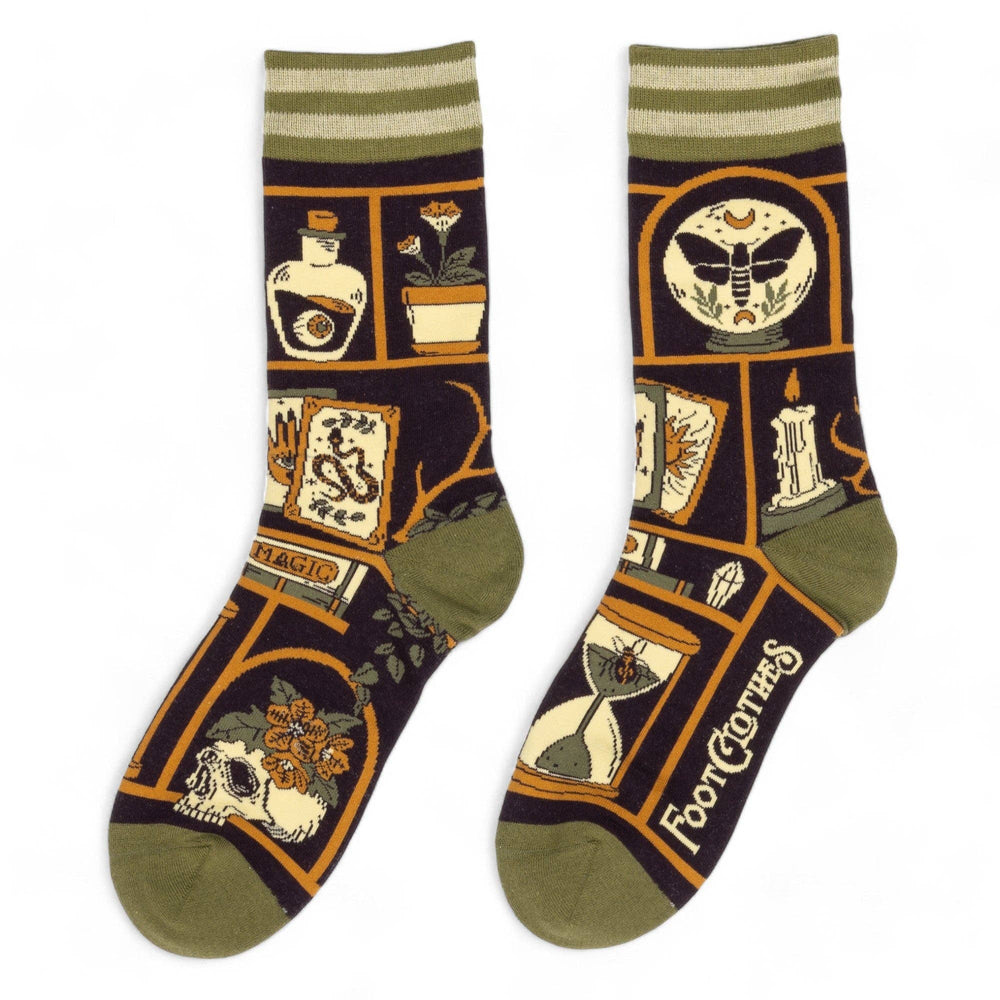 
                      
                        A model wearing a pair of socks depicting a collection of odd objects. Brown legs, green, heel, toe and cuff. 
                      
                    