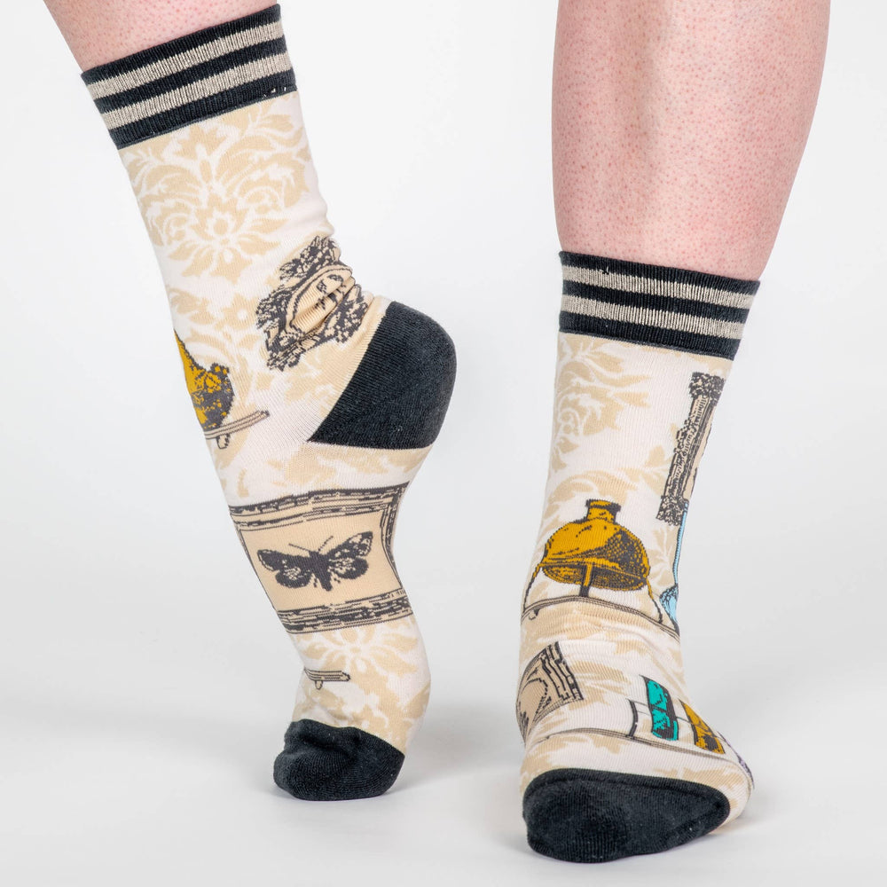 
                      
                        A pair of socks featuring antique curiosities. Cream legs, black heel, toe and cuff. 
                      
                    