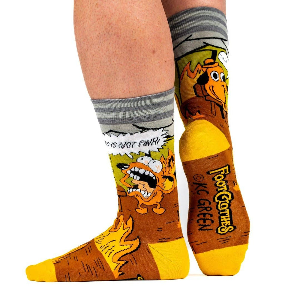 
                      
                        A model wearing a pair of socks featuring a design by KC Green. Brown flaming legs, yellow heel, toe and cuff. 
                      
                    