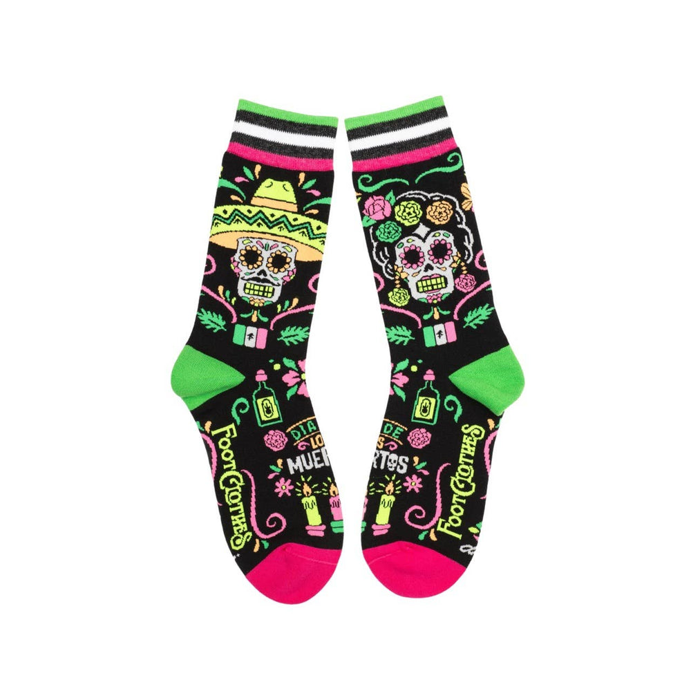 
                      
                        A model wearing a pair of socks with a day of the dead motif. Black legs, pink and green heel, toe and cuff. 
                      
                    