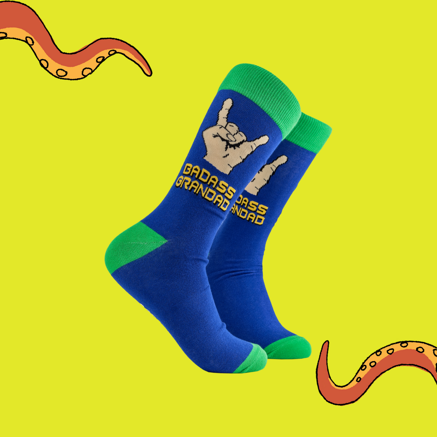 Badass Grandad Socks. A pair of socks depicting metal horns that say 'Badass Grandad. Blue legs, green cuff, heel and toe.