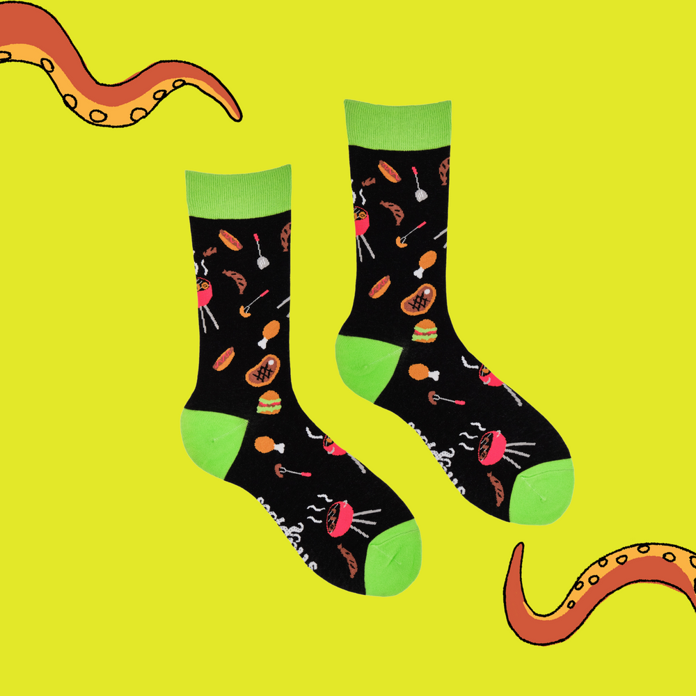 
                  
                    A pair of socks depicting Meat and BBq tools. Black legs, green cuff, heel and toe.
                  
                