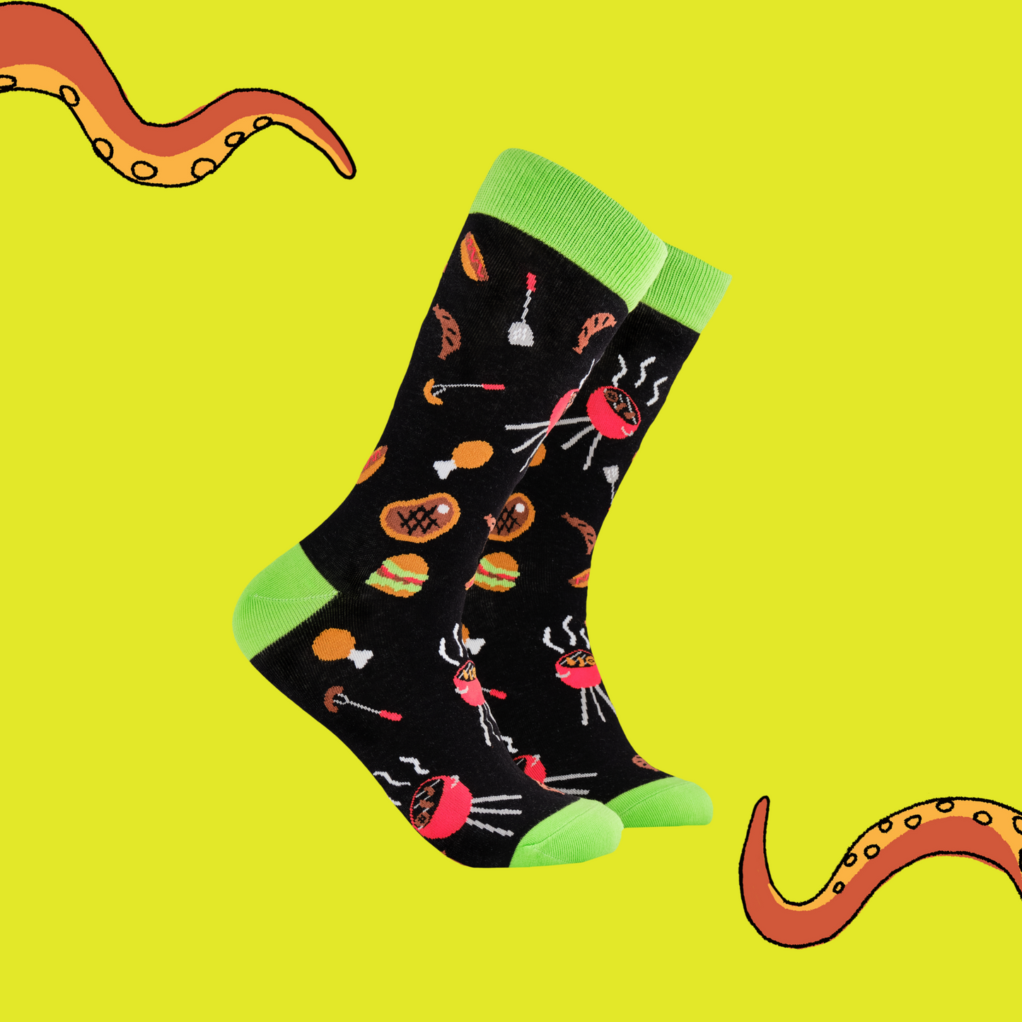A pair of socks depicting Meat and BBq tools. Black legs, green cuff, heel and toe.