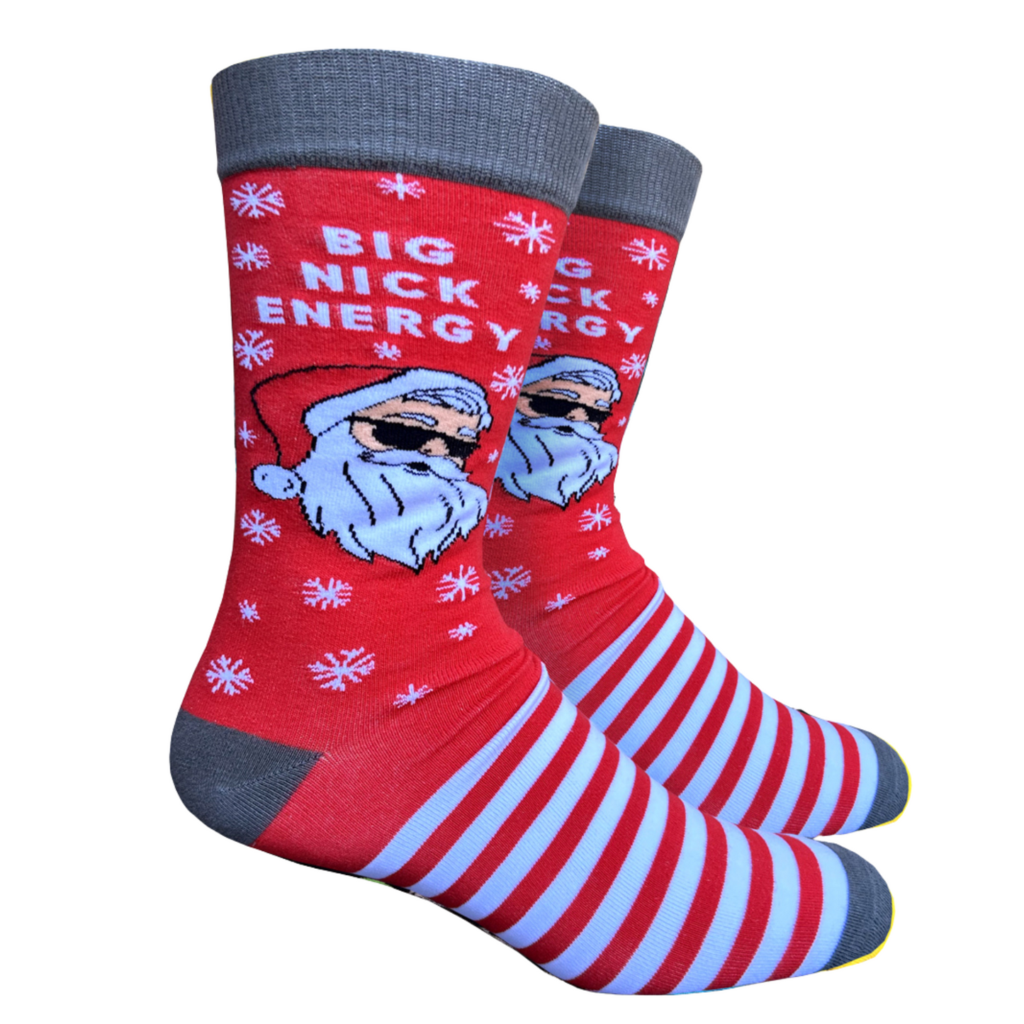 Big Nick Energy Slogan Socks. A pair of socks featuring santa wearing shades. Striped legs. Grey heel, toe and cuff. 