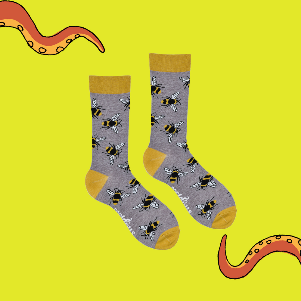 
                  
                    A pair of socks depicting Bees. Grey legs, yellow cuff, heel and toe.
                  
                