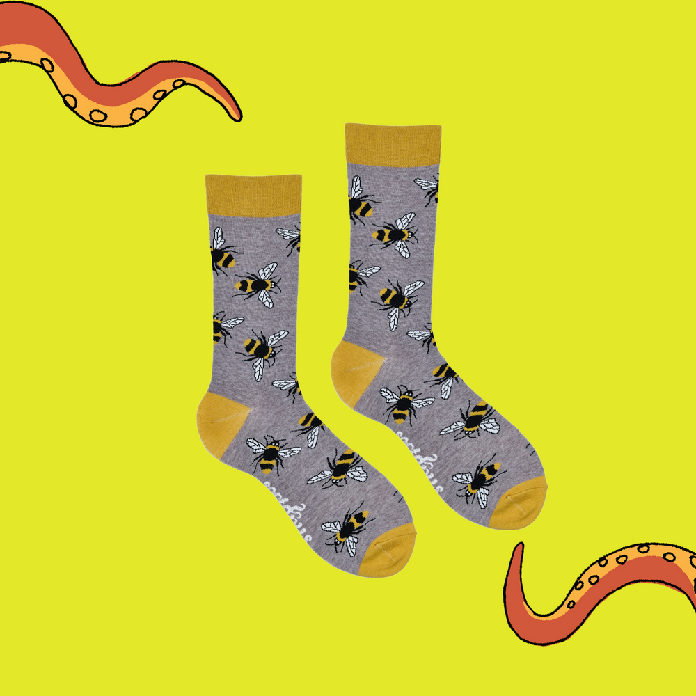 
                      
                        A pair of socks depicting Bees. Grey legs, yellow cuff, heel and toe.
                      
                    