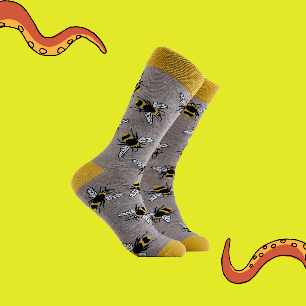 Bee Socks - Bumbling Around. A pair of socks depicting Bees. Grey legs, yellow cuff, heel and toe.