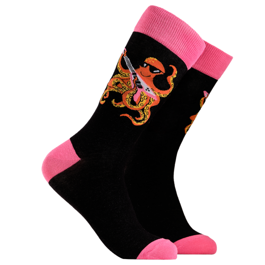 Rockstar Socks - Rocktopus. A pair of socks depicting an octopus playing a pink guitar. black legs, pink cuff, heel and toe.
