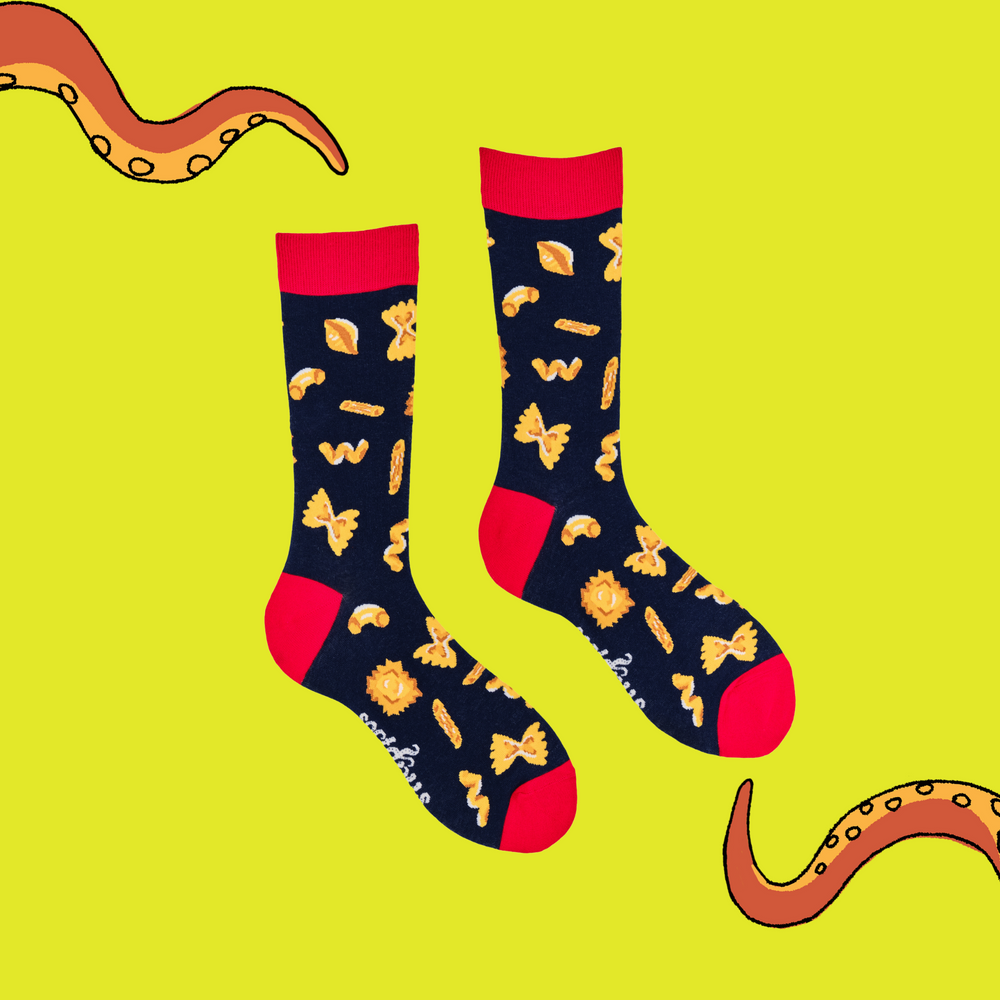 
                      
                        A pair of socks depicting different pasta shapes. Dark blue legs, red cuff, heel and toe.
                      
                    