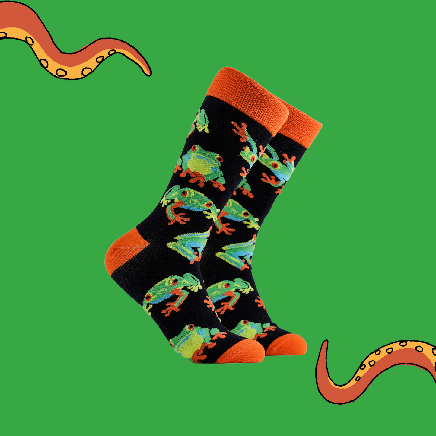 A pair of socks depicting tree frogs. Black legs, orange cuff, heel and toe.