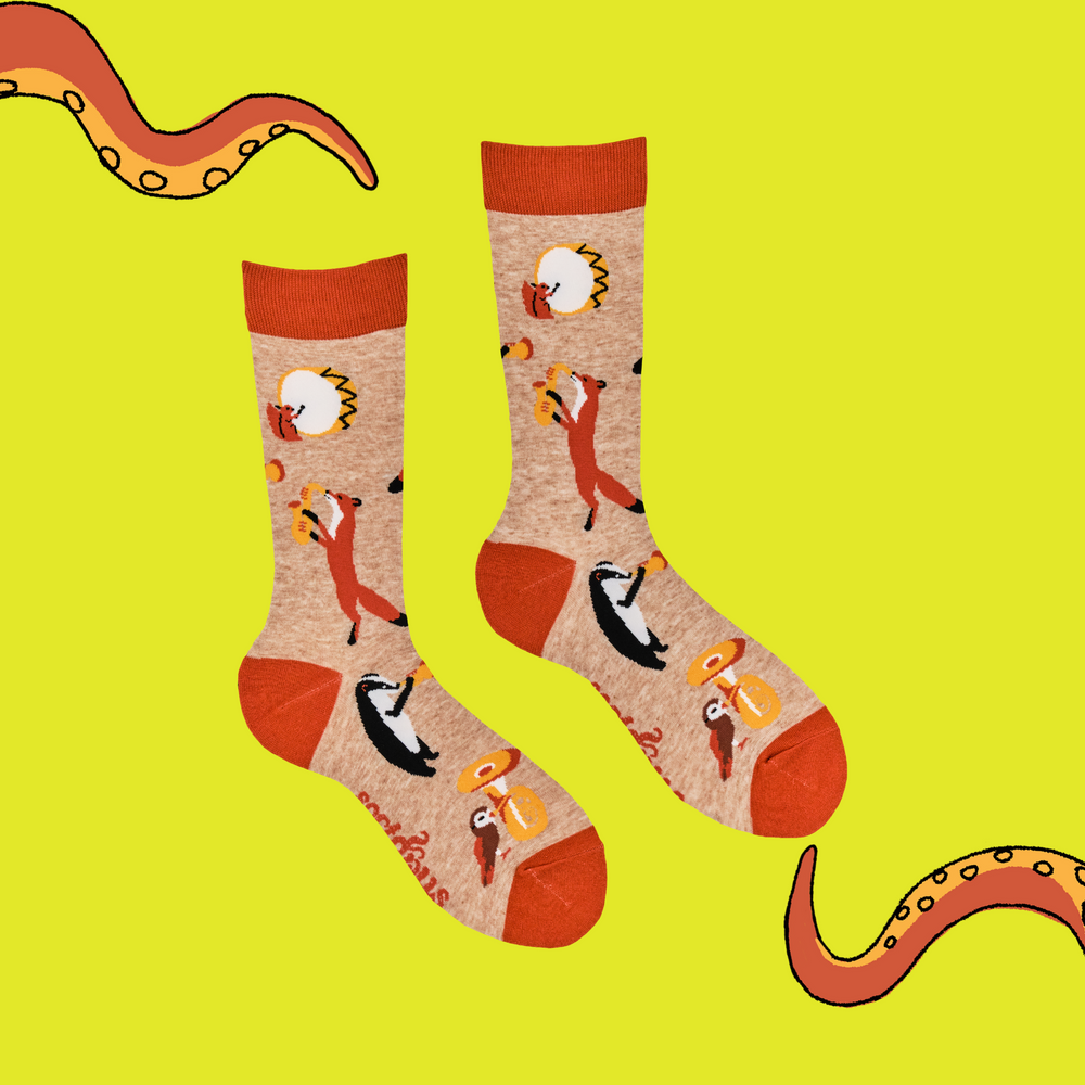 
                      
                        A pair of socks featuring some woodland creatures playing musical instruments. Brown legs, orange cuff, toe and heel. 
                      
                    