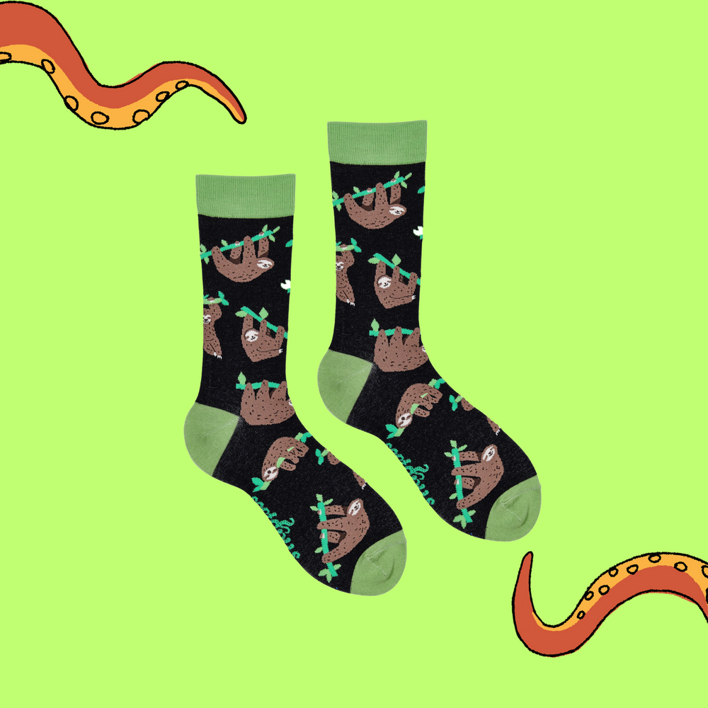 
                      
                        A pair of socks depicting lazy sloths. Black legs, green cuff, heel and toe.
                      
                    