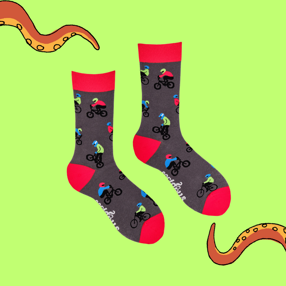 
                  
                    A pair of socks depicting people riding BMX bikes. Grey legs, red cuff, heel and toe.
                  
                