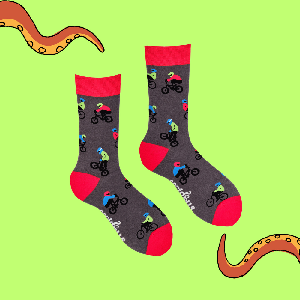 
                      
                        A pair of socks depicting people riding BMX bikes. Grey legs, red cuff, heel and toe.
                      
                    