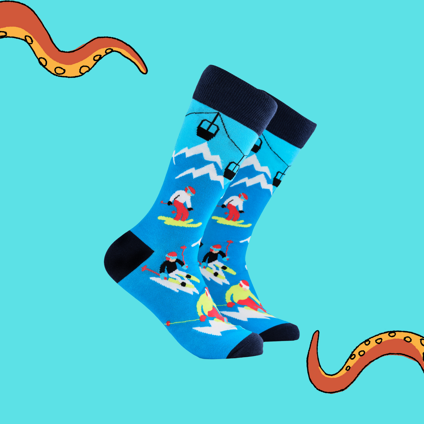 A pair of socks depicting skiers on the slopes. Blue legs, dark blue cuff, heel and toe.