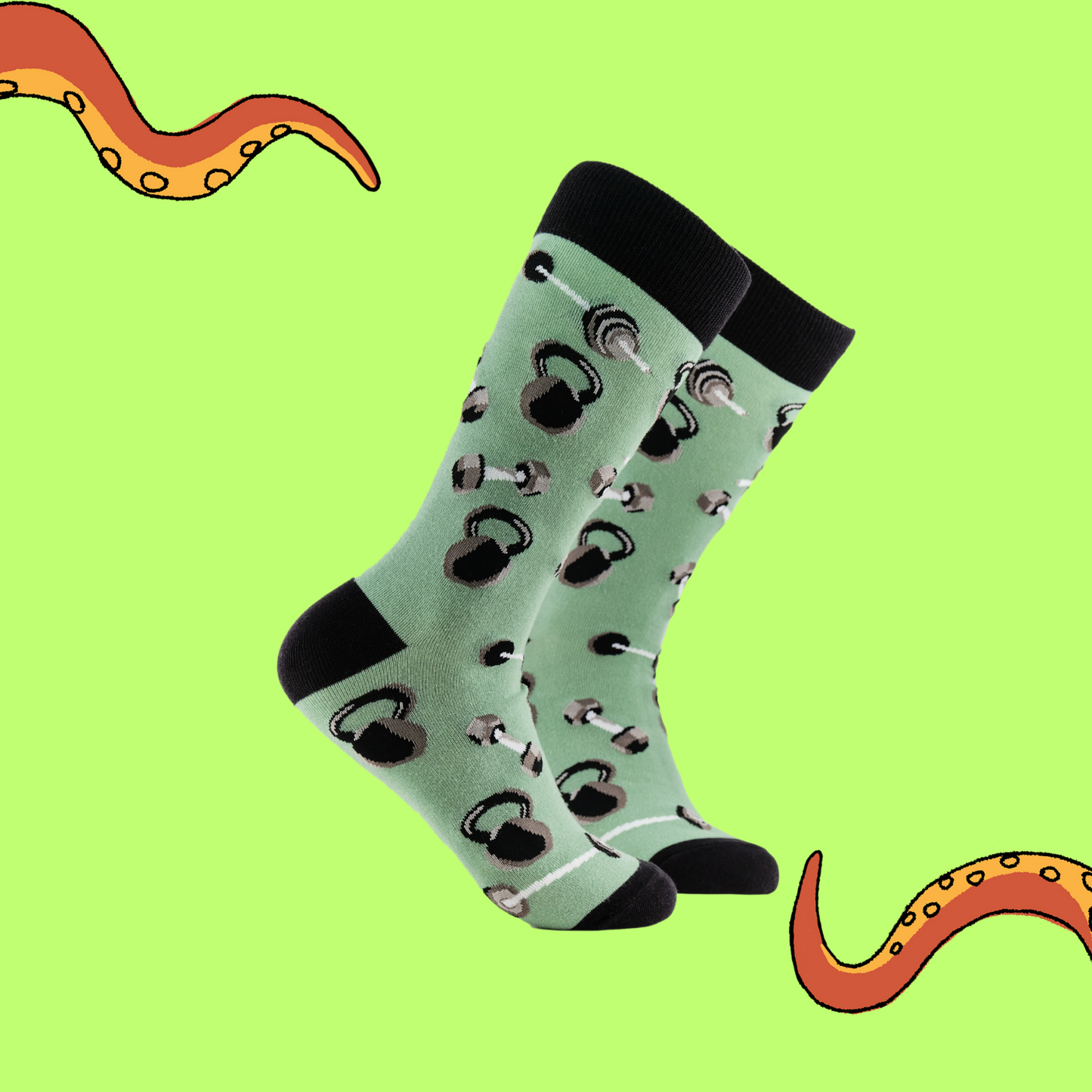 A pair of socks depicting dumb bells and kettle bells. Green legs, black cuff, heel and toe.