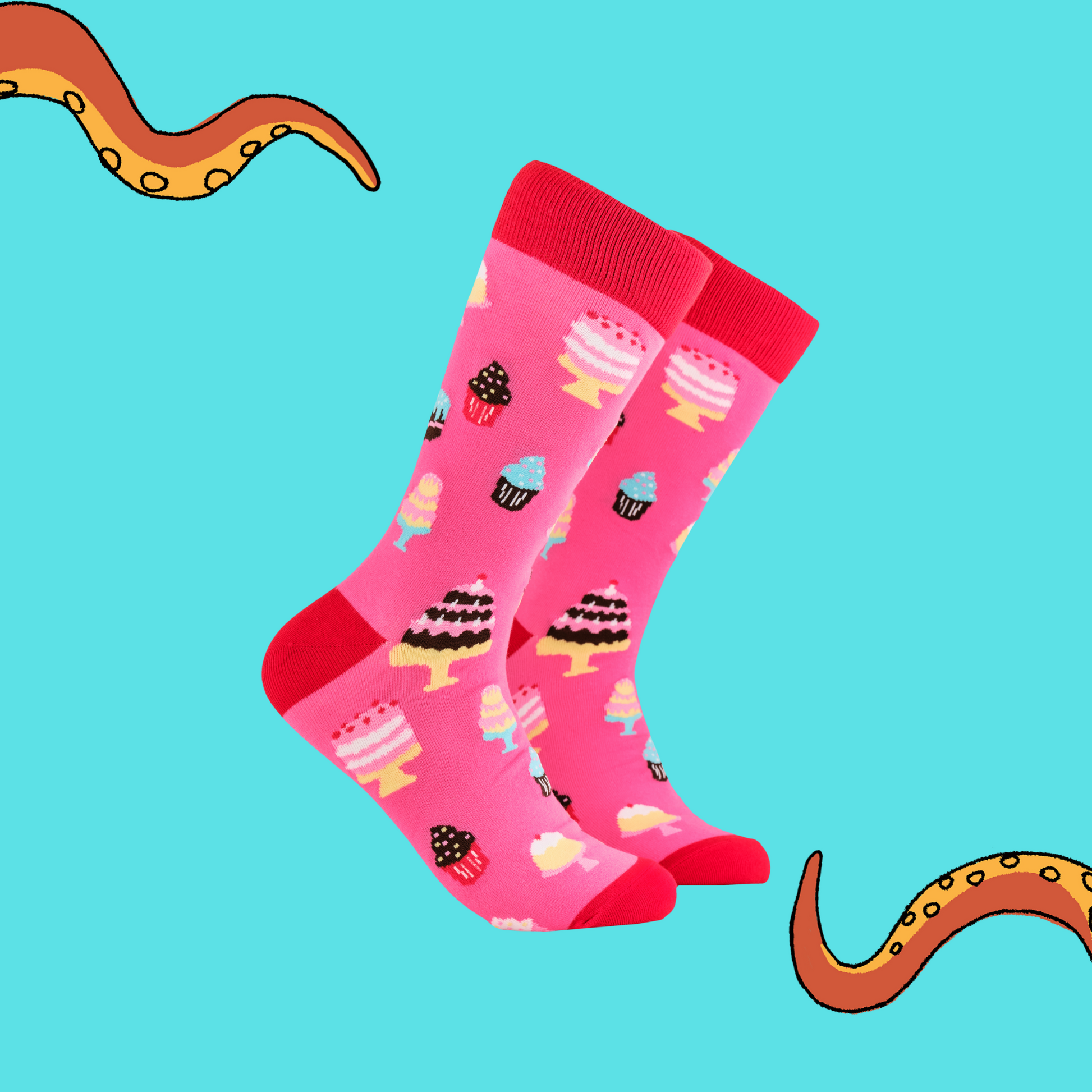 A pair of socks depicting cakes. Pink legs, red cuff, heel and toe.