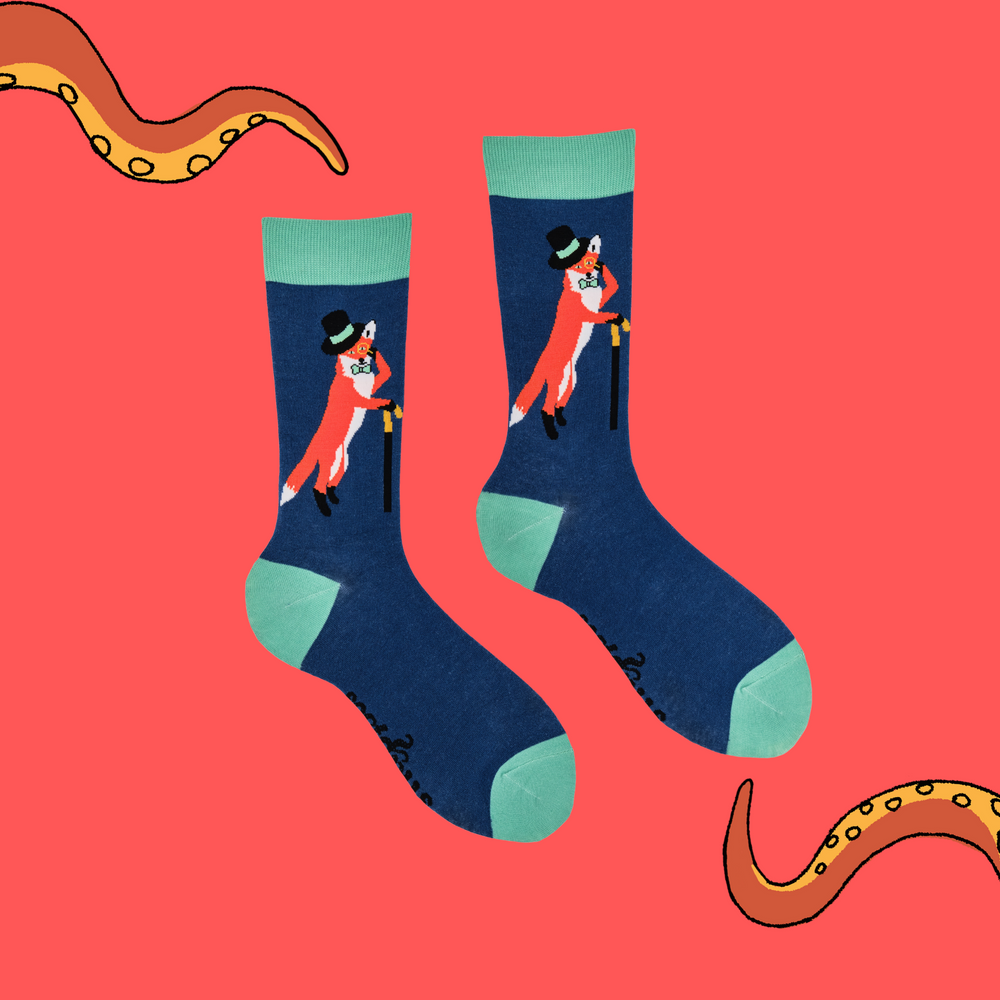 
                      
                        A pair of socks depicting a fox in a top hat and monocle. Blue legs, green cuff, heel and toe.
                      
                    