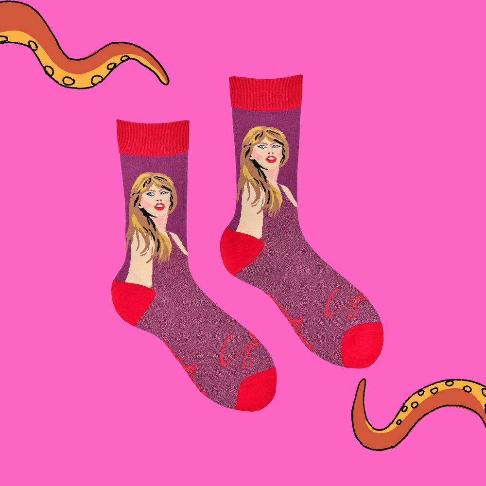 
                      
                        A pair of socks featuring Taylor Swift. Pink glittery legs, red heel toe and cuff. 
                      
                    