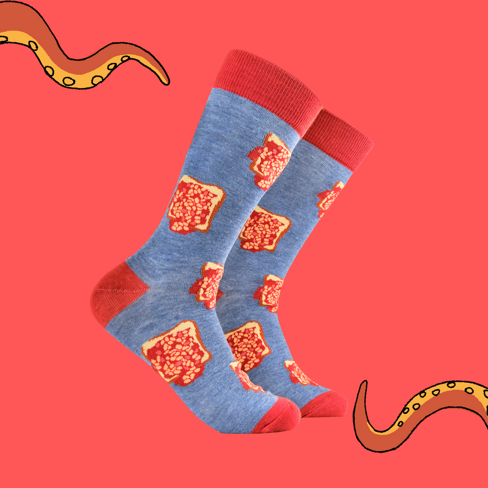 A pair of socks depicting beans on toast. Blue legs, red heel, toe and cuff. 