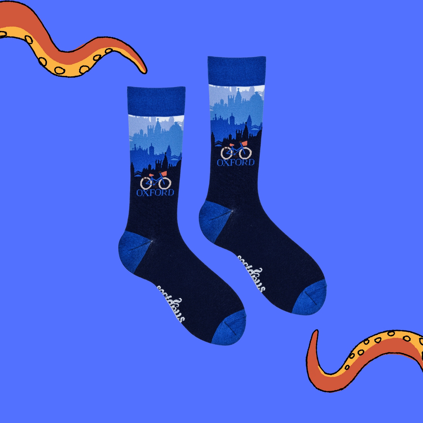 
                  
                    A pair of socks depicting the Oxford skyline and a traditional bicycle. Blue legs, blue cuff, heel and toe.
                  
                