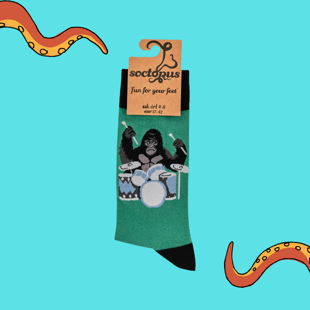 
                      
                        A pair of socks featuring a drumming gorilla. Green legs, black heel, toe and cuff. 
                      
                    