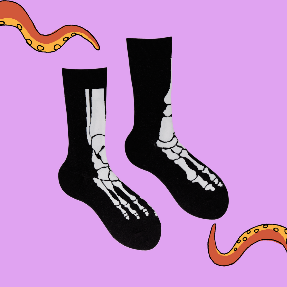 
                  
                    A pair of socks depicting skeleton feet. Black and White legs, black cuff, heel and toe.
                  
                