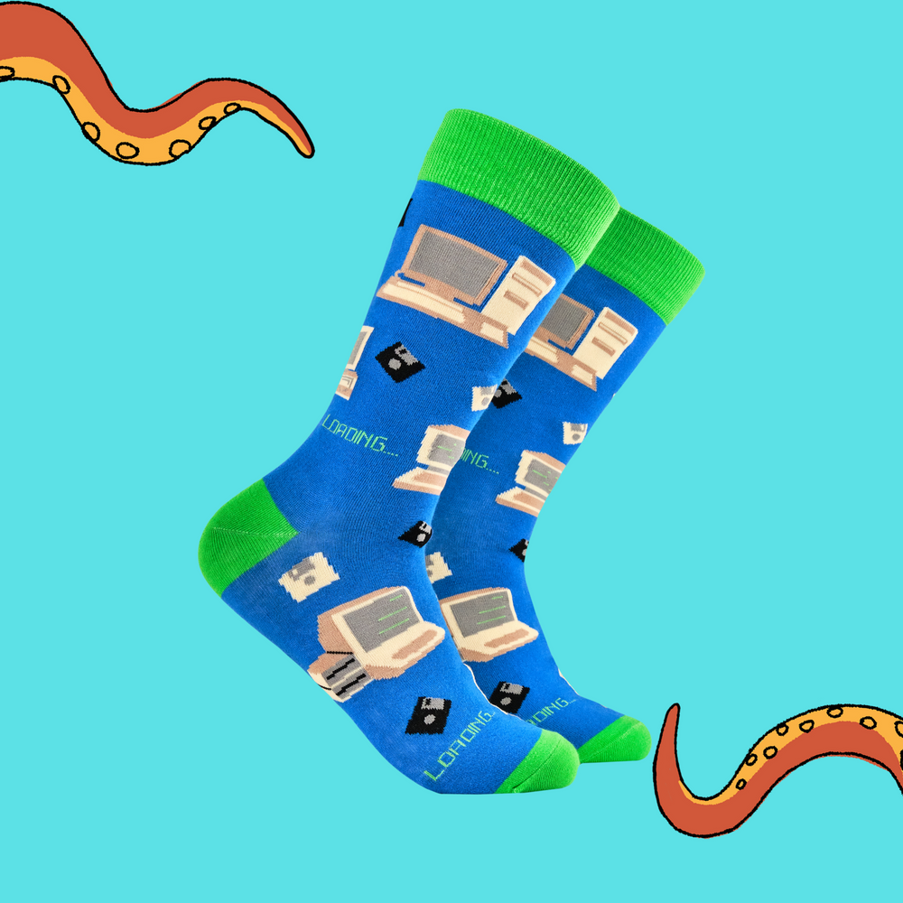 A pair of socks featuring old school computers and floppy disks. Blue legs, green heel, toe and cuff. 