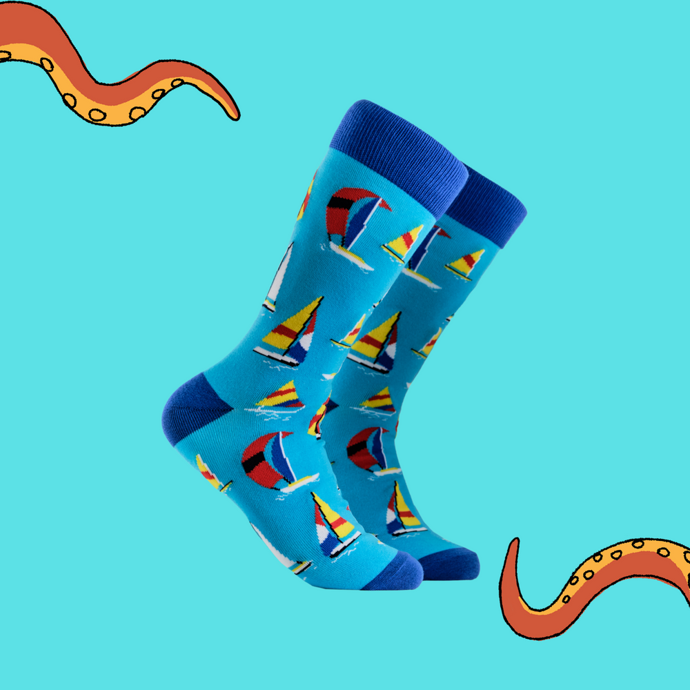 A pair of socks depicting sailing boats. Blue legs, dark cuff, heel and toe.