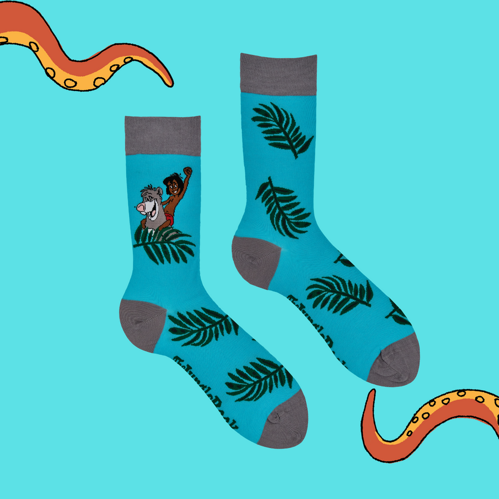 
                      
                        A pair of socks depicting Mowglie and Baloo playing in the jungle. Turquoise legs, grey toes, heel and cuff.
                      
                    