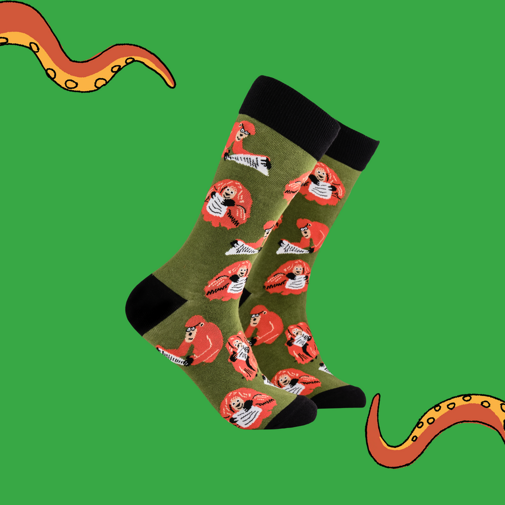 A pair of socks depicting clever Orangutans. Green legs, black cuff, heel and toe.