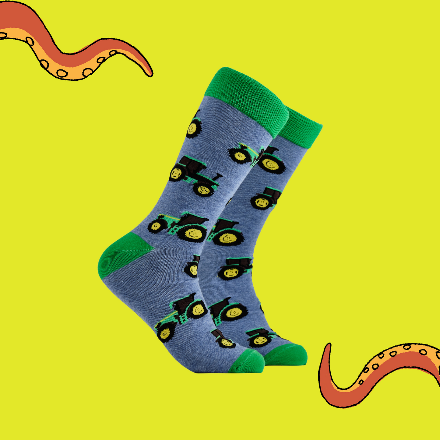 A pair of socks depicting green tractors. Blue legs, green cuff, heel and toe.