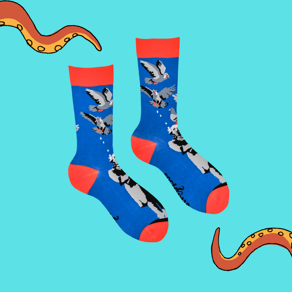 
                      
                        A pair of socks depicting pigeons pooping on a statue. Blue legs, orange heel, toe and cuff. 
                      
                    